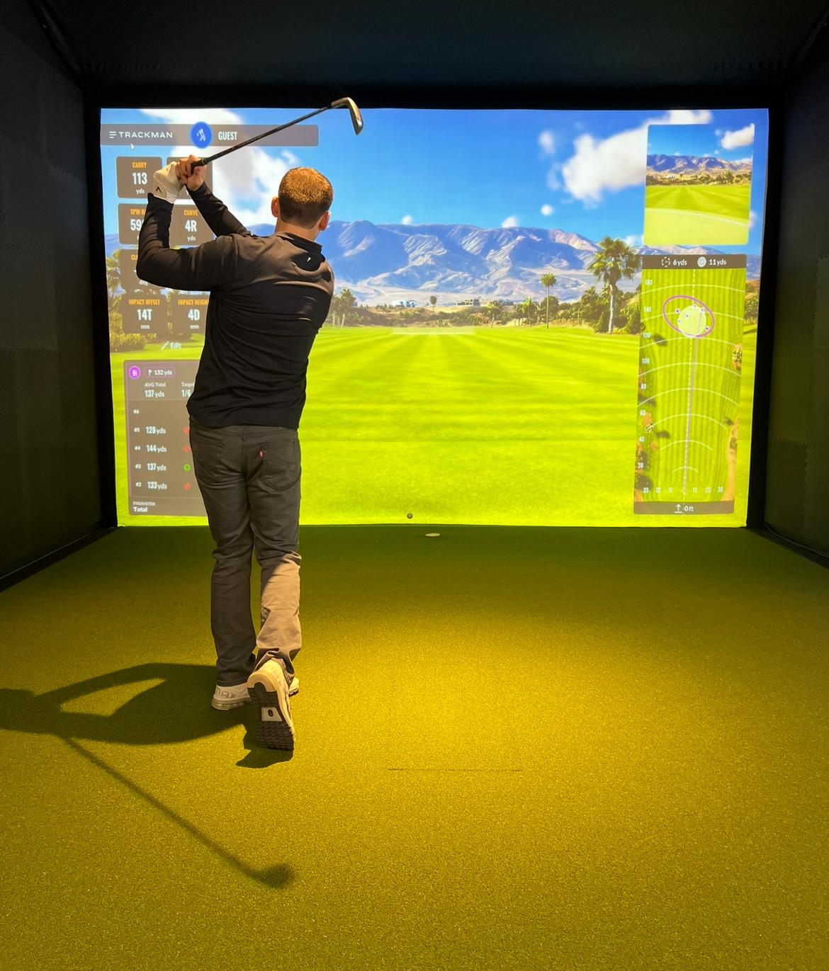 Indoor golf simulator screen and hitting area at Endless 18